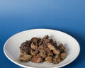 Bison Kidney Freeze-Dried Treats on a white plate against a blue background