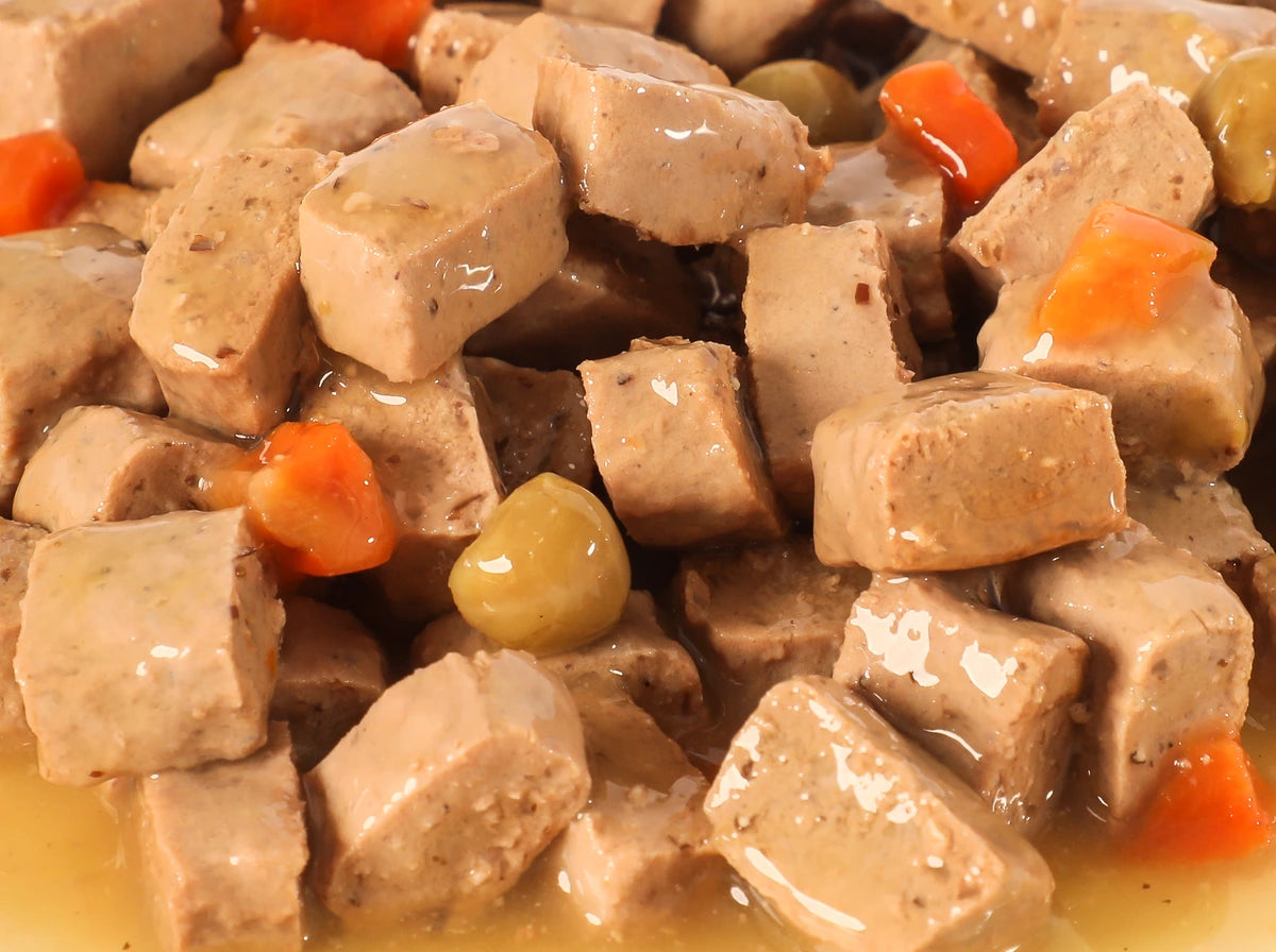 Close-up of Chicken & Vegetable Canned Recipe chunks with carrots and peas in gravy