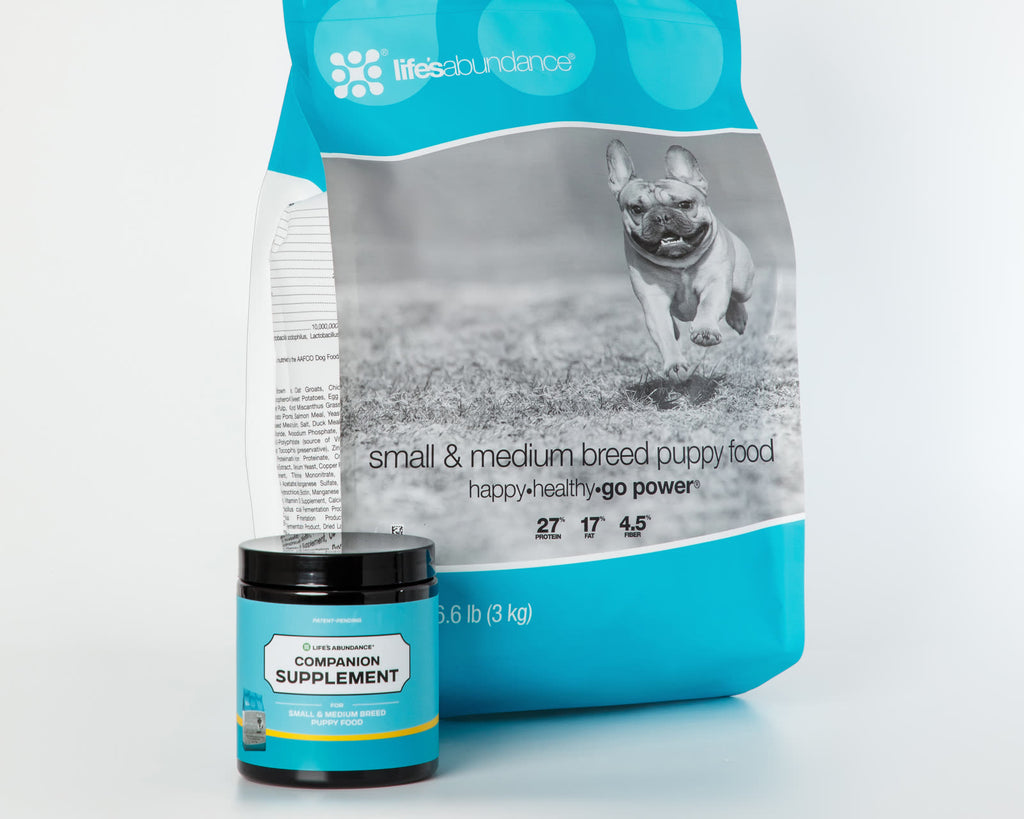 Daily Nutrition System: bag of small and medium breed puppy food with its Companion Supplement chews jar on a white studio background