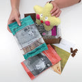 Life's Abundance dog gift basket being unboxed, with bully sticks, treats and a plush toy