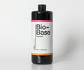 Bio-Base floorwash concentrate, black one-quart bottle with the pink and orange banded label, straight on against a pale studio seamless