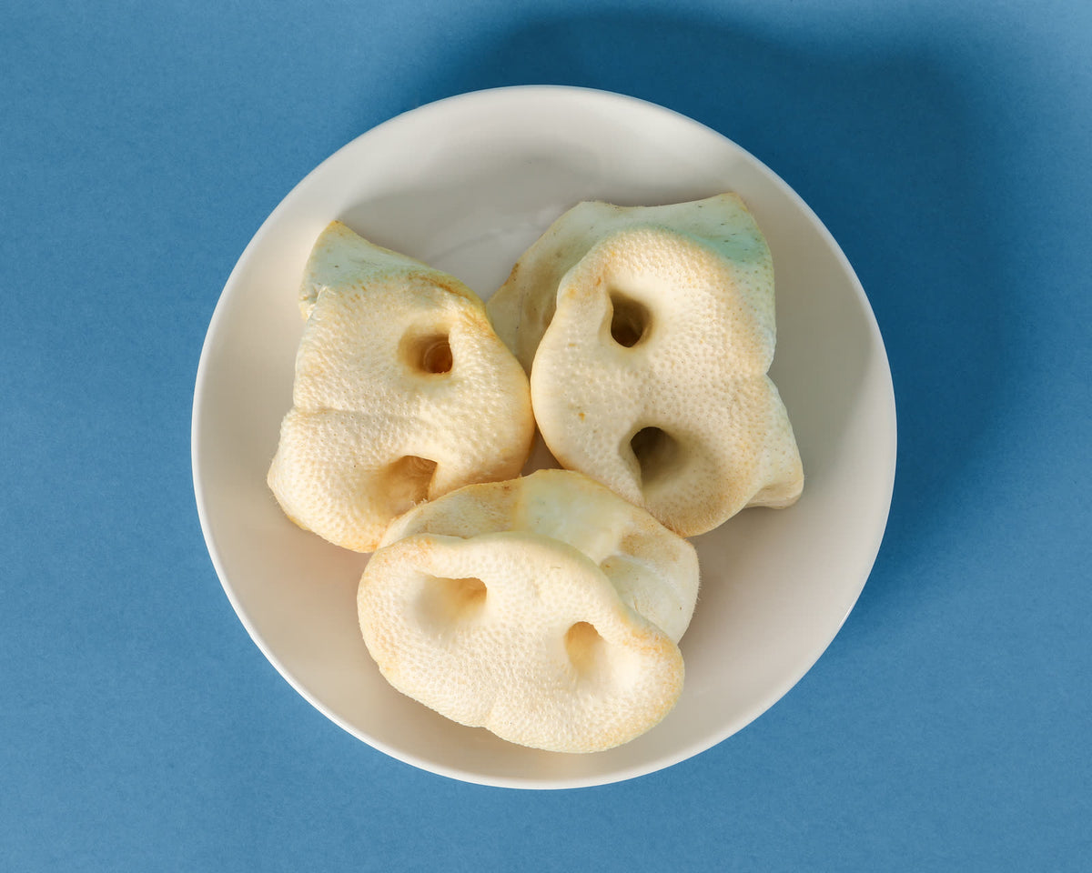 Porky Puffs pork treats in a white bowl on a blue background