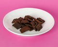 Grain Free Turkey & Berry Chewies on a white plate against a pink background