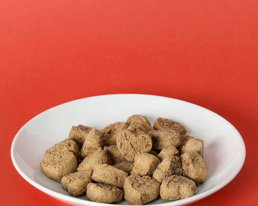 Wholesome Hearts heart-shaped treats on a white plate on a red background